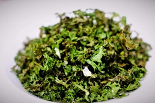 Sprød grønkålssnack i skål - sundt vegansk snackalternativ.