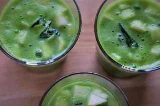 Tre glas med frisk grøn smoothie på et træbord, sund livsstil, vegetarmad.