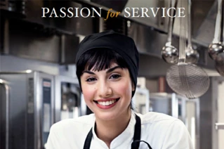 Glædelig kok i professionelt køkken med teksten 'PASSION for SERVICE'