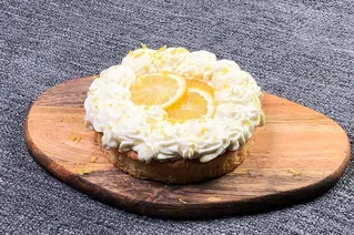 Citronmåne kage med flødeskum og citronskiver på en træskive - dansk bageri dessert.