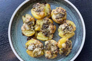 Blå tallerken med knuste kartofler og pynt på toppen