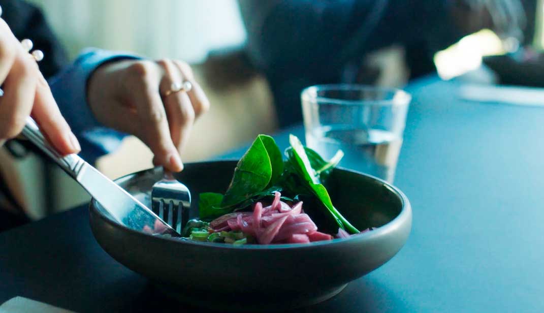 Traditionel dansk aftensmad med kylling, kogte kartofler og stegt hvidkål på en blå tallerken.