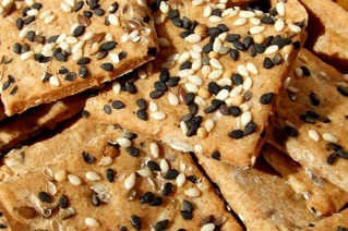Stykker af chokoladeknas med nødder og karamel i en skål.