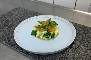 Hvid tallerken med kartofler i skiver