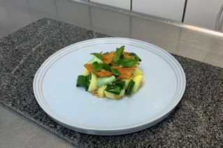 Hvid tallerken med kartofler i skiver