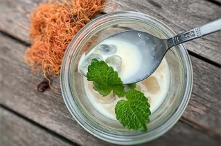 Nørbillede af glas med latte og et mynteblad