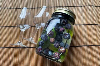 Mason jar med klar væske og bær i