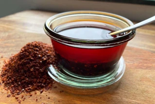 Glas med soyasauce og æbleeddikke og bunke med chili ved siden af