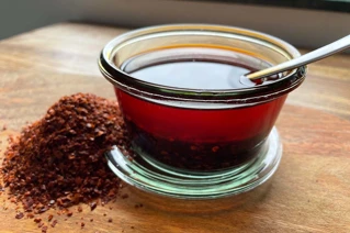 Glas med soyasauce og æbleeddikke og bunke med chili ved siden af