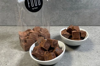 Hvide skåle med chokoladepulver dækket firkantede karameller